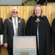 Mayor, men in uniform and vicar at a war memorial.