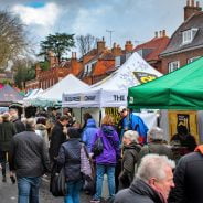 Crowd of people at an outdoor market. Colourful gazebos in street