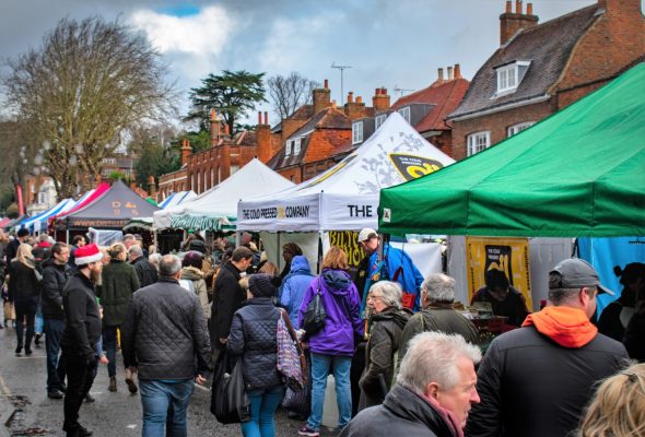 Crowd of people at an outdoor market. Colourful gazebos in street