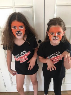 Two girls with tiger face paint.