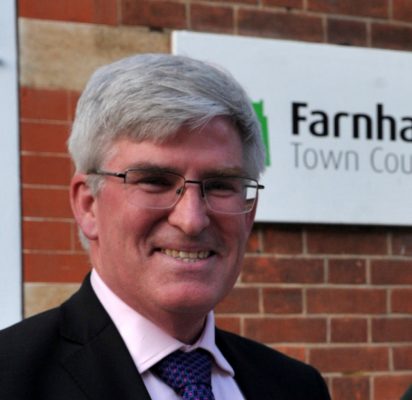 Man standing in front of Farnham Town Council sign.