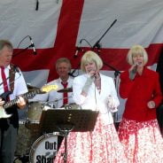 Band singing and playing on a stage.