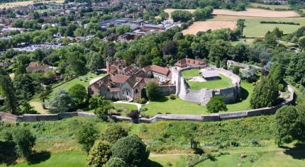 aerial photo of a castle and surrounding trees and town centre.