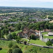 Aerial photo showing castle and green spaces and trees.