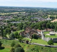 Aerial photo showing castle and green spaces and trees.