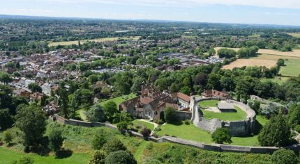 Aerial photo showing castle and green spaces and trees.