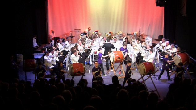 Orchestra and drummers on stage.