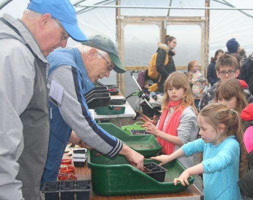 Adults and children gardening