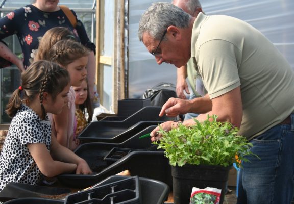 Man and children gardening.