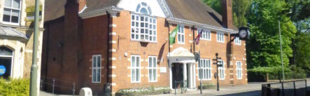 Exterior of a red brick building. Flags flying on front.
