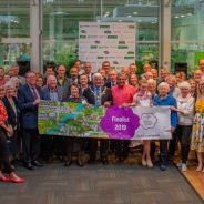 Large group of people holding a Farnham in Bloom banner