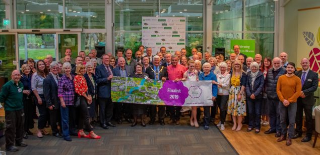 Large group of people holding a Farnham in Bloom banner