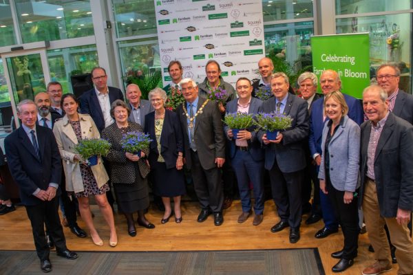 Group of people holding pot plants.