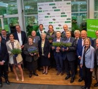 Group of people. Some holding pot plants.