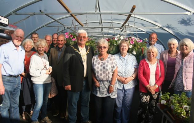 Mayor and a group of people standing inside a large poly tunnel