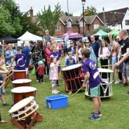 Taiko drummers watched by a crowd of people