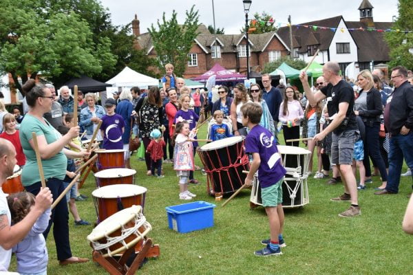 Taiko drummers watched by a crowd of people