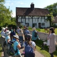 Group of walkers outside a timber framed house