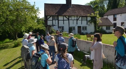 Group of walkers outside a timber framed house