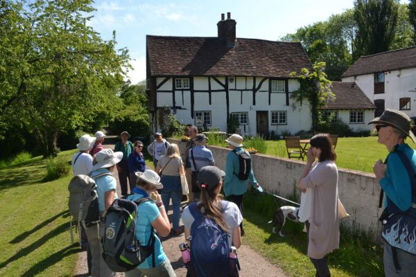 Group of walkers outside a timber framed house