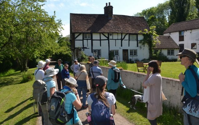 Group of walkers outside a timber framed house