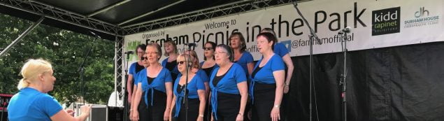 Group of females on a stage singing