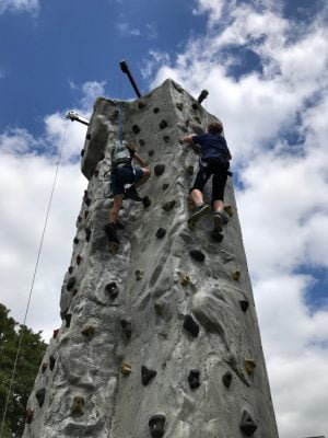 Two people up a climbing wall.