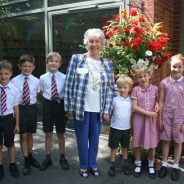 School children with the Mayor of Farnham in front of a hanging basket.