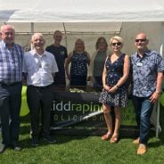 Group of people standing in front of a small marquee.