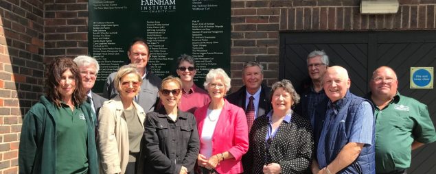 Group of people standing in front of a sign.