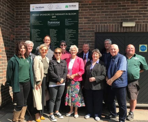 Group of people standing in front of a sign.