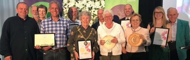 Group of people holding certificates and trophies
