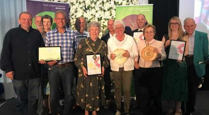 Group of people holding certificates and trophies