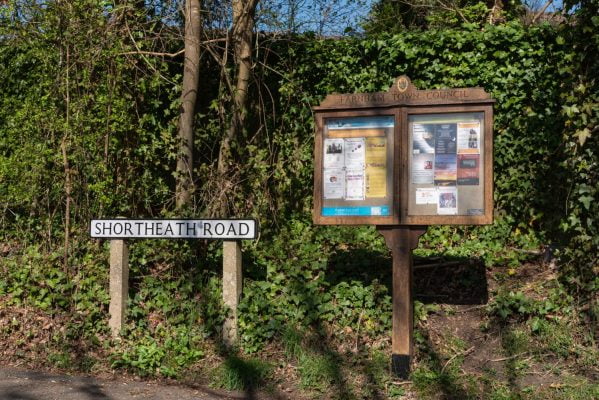 Wooden noticeboard displaying posters