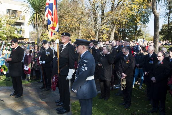 Solider and crowd bow heads during act of remembrance