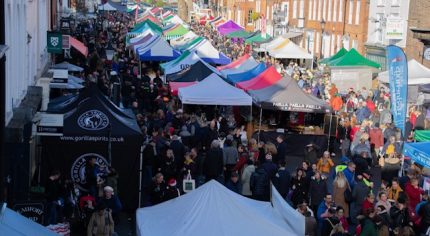 Aerial view of crowded street market and colourful marquees