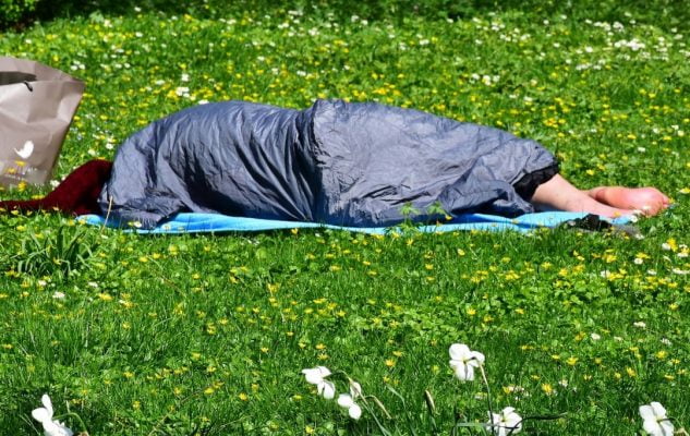 Person sleeping rough on grass
