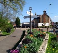 Street scene with wooden directional sign and flowers