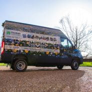 Van wrapped in floral vinyl and parked on gravel