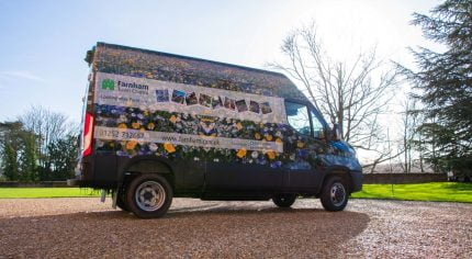Van wrapped in floral vinyl and parked on gravel