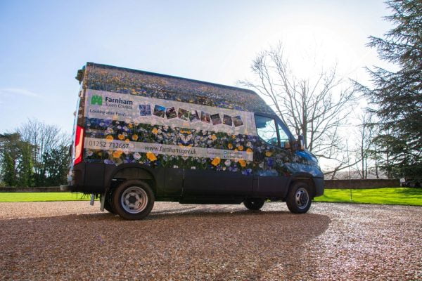 Van wrapped in floral vinyl and parked on gravel