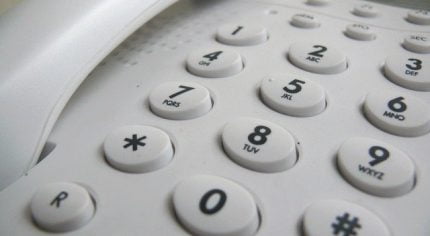 Close up showing push buttons on a white telephone