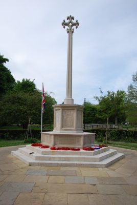 Stone war memorial with poppy wreaths at base.