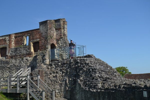 Scottish piper playing bagpipes on top of a castle