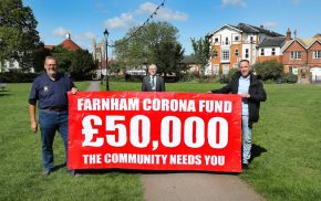 Three men holding banner advertising fundraising appeal