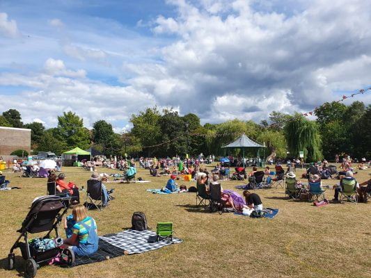 People sitting on blankets in a parkland setting