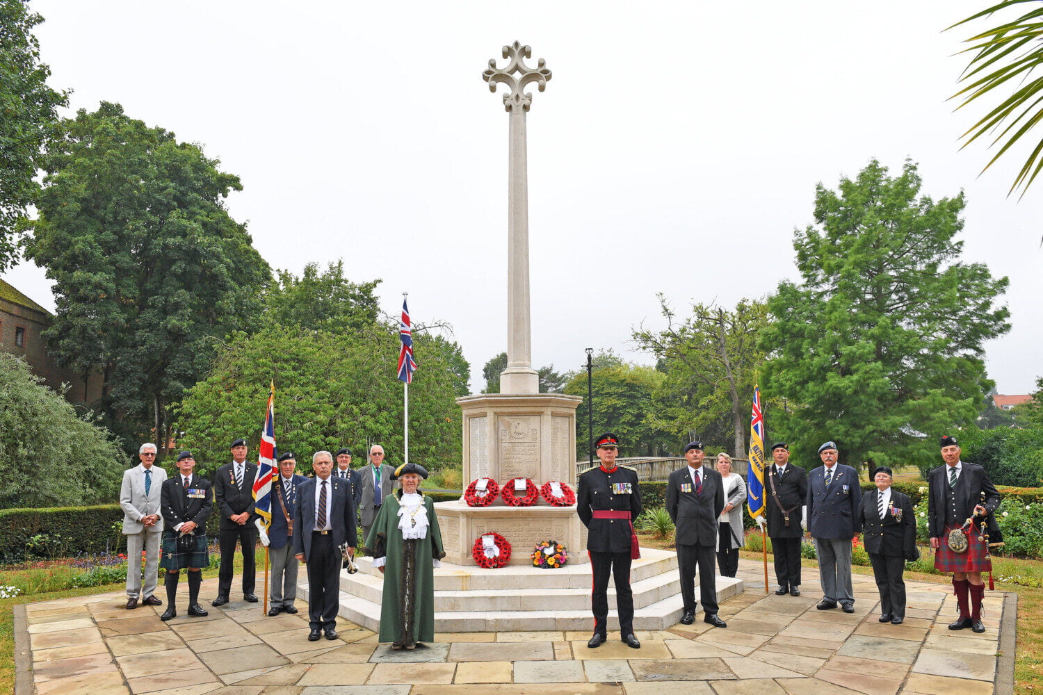 People standing around war memorial.