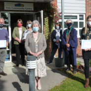 Group of people wearing masks and socially distancing.