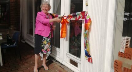 Mayor cuts ribbon at entrance to a building