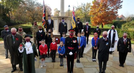 School children, the Mayor and others socially distance at the war memorial.